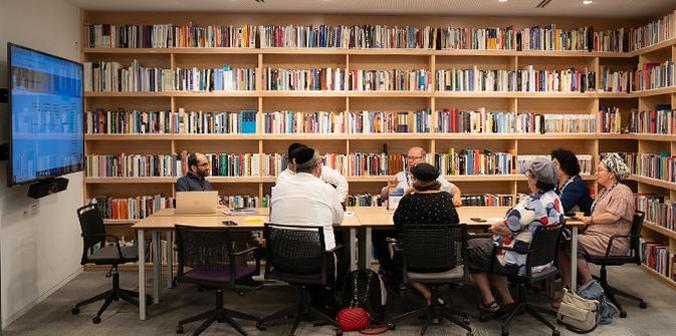 Librarians and Mandel faculty and staff meet in the library