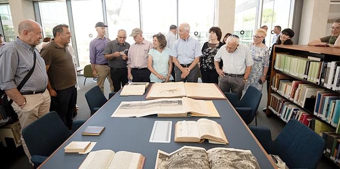 People standing around a large table with rare books